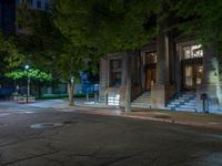 a city street at night with parking meters on either side and the road in the center