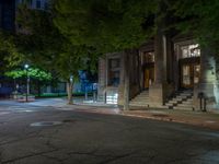 a city street at night with parking meters on either side and the road in the center