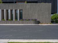 a building with a logo painted on the side near a street that has a sidewalk next to it