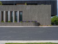 a building with a logo painted on the side near a street that has a sidewalk next to it