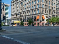 an empty street with buildings and parked cars on the sidewalks and green lanes on the sidewalk