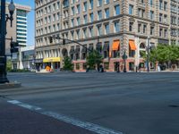 an empty street with buildings and parked cars on the sidewalks and green lanes on the sidewalk