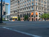 an empty street with buildings and parked cars on the sidewalks and green lanes on the sidewalk