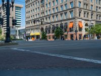 an empty street with buildings and parked cars on the sidewalks and green lanes on the sidewalk