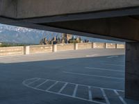 several large empty parking spaces in the city with buildings nearby in front of them -