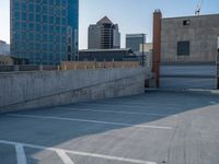 several large empty parking spaces in the city with buildings nearby in front of them -