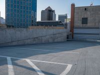 several large empty parking spaces in the city with buildings nearby in front of them -