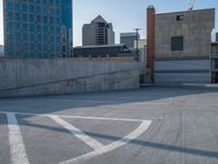 several large empty parking spaces in the city with buildings nearby in front of them -