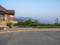 a building that has a bunch of windows on it at sunset with mountains in the background