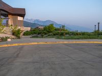 a building that has a bunch of windows on it at sunset with mountains in the background