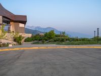 a building that has a bunch of windows on it at sunset with mountains in the background