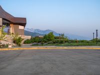 a building that has a bunch of windows on it at sunset with mountains in the background