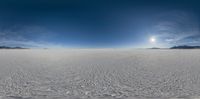 a photo taken from inside of a snow field showing the sun in the sky and the horizon