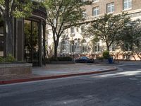 an intersection with an umbrella stand at the end of the street and cars parked next to it