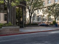 an intersection with an umbrella stand at the end of the street and cars parked next to it