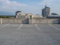 several large empty parking spaces in the city with buildings nearby in front of them -