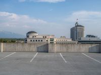 several large empty parking spaces in the city with buildings nearby in front of them -