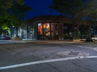 a city street at night with parking meters on either side and the road in the center