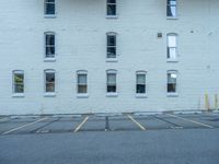 a street with a building near the building in the middle and on the left of which is a parking lot, as shown in this photo