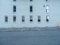 a street with a building near the building in the middle and on the left of which is a parking lot, as shown in this photo