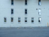 a street with a building near the building in the middle and on the left of which is a parking lot, as shown in this photo