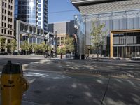 yellow fire hydrant on the street near a building with a glass front and walkway