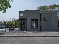 a store on the corner in a small town that has lots of gray brick walls