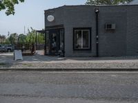 a store on the corner in a small town that has lots of gray brick walls