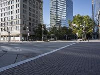 an empty street is seen in the middle of town during the day on a clear blue sky day