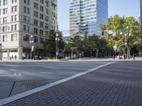 an empty street is seen in the middle of town during the day on a clear blue sky day