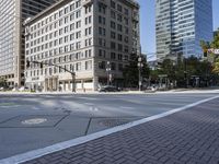 an empty street is seen in the middle of town during the day on a clear blue sky day