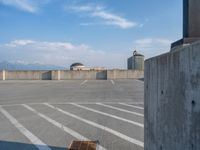 several large empty parking spaces in the city with buildings nearby in front of them -