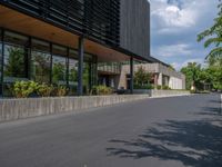 a building with a logo painted on the side near a street that has a sidewalk next to it