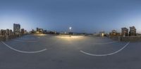 a night time image of a parking lot at dusk with the lights on in the distance