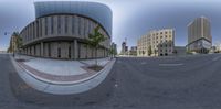 a wide angle fisheye lens image of an intersection in a large city center with skyscrapers in the distance