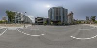 a panorama photo of city buildings and street with white lines down the middle of the road