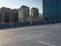 several large empty parking spaces in the city with buildings nearby in front of them -