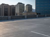 several large empty parking spaces in the city with buildings nearby in front of them -