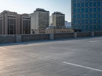 several large empty parking spaces in the city with buildings nearby in front of them -