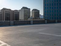 several large empty parking spaces in the city with buildings nearby in front of them -