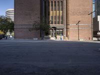 an empty street with cars in front of large buildings and tall windows with lots of windows