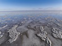 view from the airplane's side shows the water and sand that looks like water in the sky