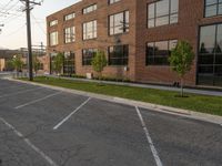 an empty street in front of a large red brick building on the other side of the road is a street light that has a line for motorists