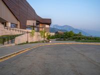 a building that has a bunch of windows on it at sunset with mountains in the background