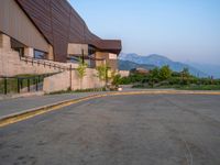 a building that has a bunch of windows on it at sunset with mountains in the background