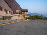 a building that has a bunch of windows on it at sunset with mountains in the background