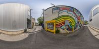 three large cylindrical shaped buildings with graffiti on them near each other in the daytime and in the evening