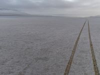 an empty road leads to the horizon in the winter time at an expansive plain near the coast