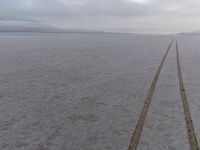 an empty road leads to the horizon in the winter time at an expansive plain near the coast