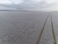 an empty road leads to the horizon in the winter time at an expansive plain near the coast